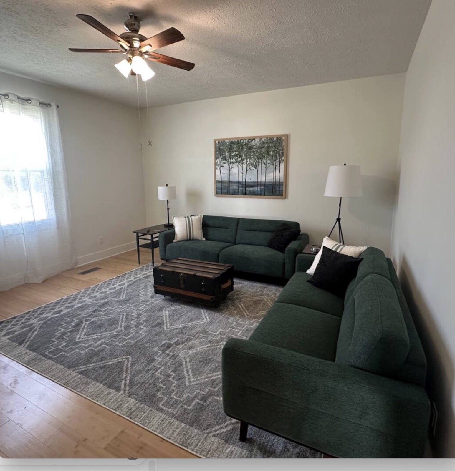 Living room with two green sofas at Main Street Retreat